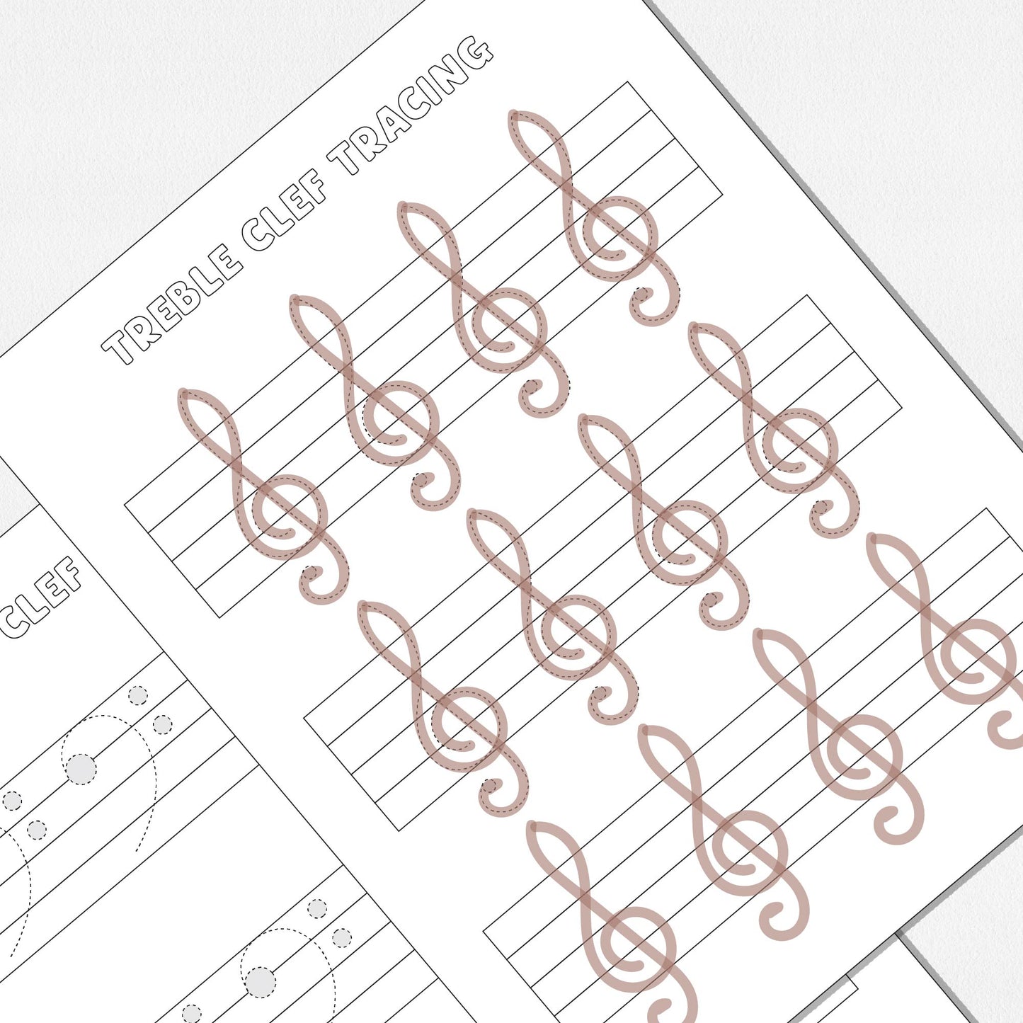 A close up view of two worksheets, one for tracing and drawing treble clefs and one for tracing and drawing bass clefs. Shown on a neutral colored background.