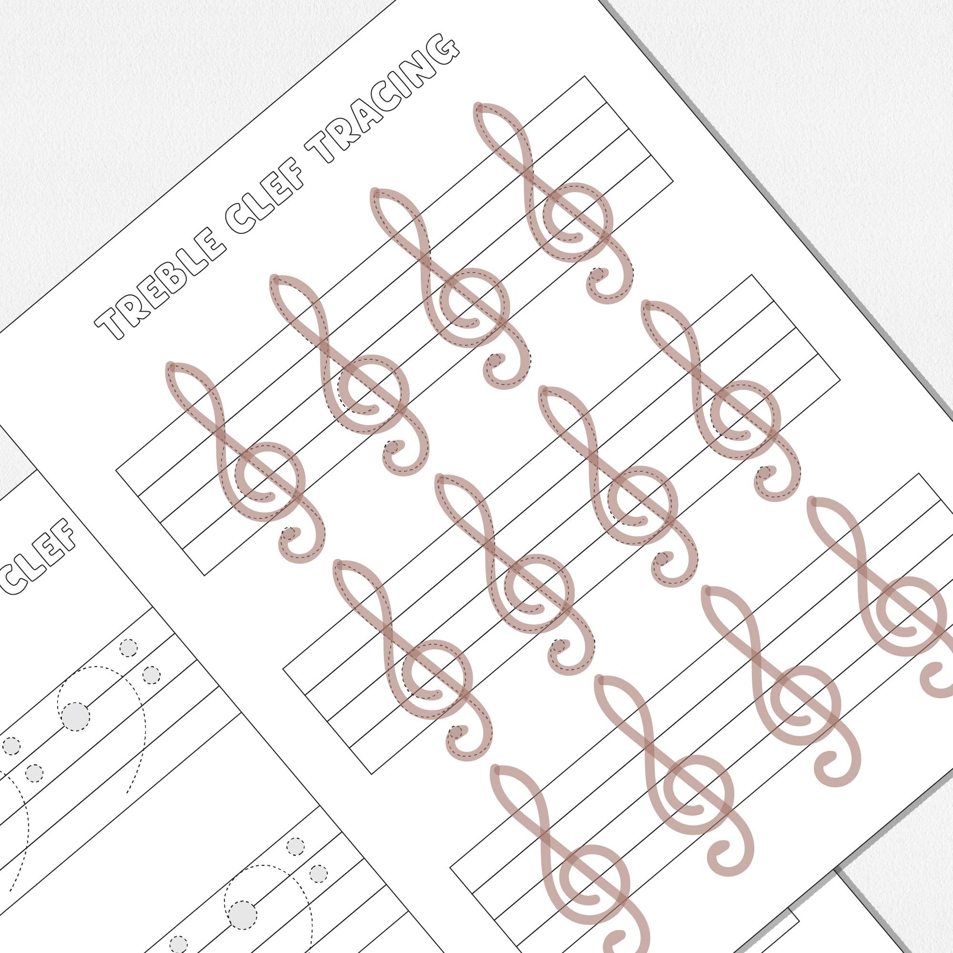 A close up view of two worksheets, one for tracing and drawing treble clefs and one for tracing and drawing bass clefs. Shown on a neutral colored background.