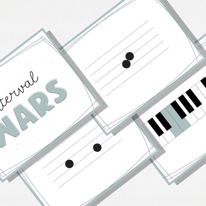 A zoomed in image of four square cards of a music card game showing music notes on a staff, a piano keyboard, and a cover card with text that says "Interval Wars." Shown on a neutral colored background